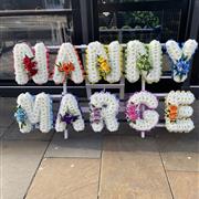 Rainbow Nanny Floral Tribute on Wooden Stand